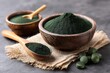 © EchoFrame - Spirulina Powder and Tablets in Wooden Bowls and Spoon on Rustic Cloth, Close-Up Still Life, Healthy Food Concept