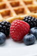 © rukxstockphoto - Close up fresh raspberry blueberry and blackberry topping on waffle background