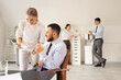© Pixel-Shot - Young business people with glasses of water from cooler working in office