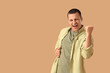 © Pixel-Shot - Handsome young happy man on beige background