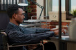 © DC Studio - Employee with special needs uses a laptop to analyze ecommerce statistics, creating a financial development project while seated in a wheelchair at work.