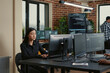 © DC Studio - Programmer holding a clipboard sits near a colleague writing code as database admins work on big data, machine learning software and a shared development project.