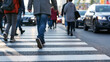 © Tetyana - Pedestrians crossing city street on a zebra crosswalk during rush hour, showing movement and an active urban environment with blurring cars