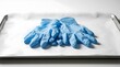 © Yusri - Pair of blue nitrile medical gloves resting on a metal tray in a lab