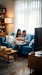© Yami - Young family sitting on a couch in the living room watching television together.