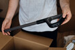 © sav_an_dreas - Person holding the handle of a cordless vacuum cleaner while assembling.