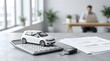 © Howward - White car model on calculator with keys for automotive finance planning