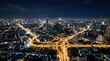 © Keo - A stunning aerial photograph captures a sprawling cityscape at night. The image showcases Bangkok, Thailand, with its dense network of illuminated buildings, highways, and waterways.