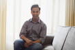 © IndiaPix - Young man sitting on sofa at home