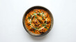 © YESI - Delicious creamy chicken curry with herbs served in a black bowl on a white background