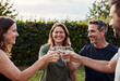 © Pixel-Shot - Group of happy friends toasting with water glasses outdoors, celebrating friendship and healthy lifestyle in a garden setting