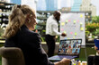 © DC Studio - An employee joins a virtual meeting on a laptop for project planning and an online presentation during an outdoor work session in a business park.
