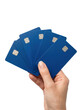 © IDA FAR - A hand holding a fan of blank blue credit cards against a clean white background in a minimalist studio shot with a professional mood.
