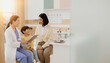 © Healthy-Go - A Doctor Consults With A Young Patient and Their Parent in a Bright Medical Office Examining a Tablet Together
