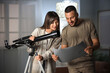© Pixel-Shot - Young couple with map and telescope in room at night