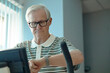 © Westend61 - Senior man checks smartwatch during fitness rehabilitation at the gym