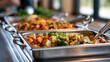 © Denis Yevtekhov - Stainless buffet pans display freshly cooked dishes in a bright self-service cafeteria, hot meal, food service, school lunch, vegetables, balanced menu, clean counter, institutional