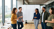 © Olena Apetroaiei - Coworkers laugh together around a blank whiteboard in a sunlit meeting room, capturing bright, collaborative team connection.
