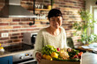 © Davor - Smiling woman unpacking fresh produce in home kitchen