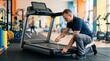 © Gabriel - Man servicing a treadmill in a gym