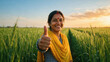 © Niks Ads - happy indian female showing thumbs up standing at green agricultural field