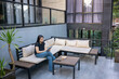 © Sino Images Studio - Asian woman using digital tablet while sitting on outdoor patio couch