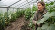 © Thiago - Female farmer standing inside a greenhouse surrounded by cucumber plants