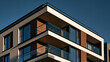 © Momin Photo Gallery - Elegent photo of Modern luxury apartment building exterior against a clear blue sky. Ideal for real estate investment, property development, or urban living concept ads.