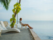 © Anna Tsukanova/Stocksy - Man working with laptop sitting by the pool at seaside