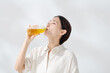 © naka - ペットボトルのお茶を飲む女性