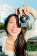 © ADDICTIVE STOCK - Gen Z Chinese woman taking a photo with a vintage camera