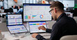 © Andrey Popov - Young Sales Manager Uses Dual Touchscreen Laptop Tracking Customer Leads