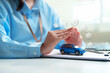 © Joi_studio - Car insurance concept with miniature vehicle protected by hands, vehicle insurance, financial protection, auto loan, warranty, roadside assistance, risk management, and secure vehicle ownership