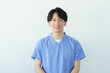 © gohan - 白背景のスクラブを着た若い日本人男性整体師