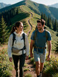 © Andrei - Smiling young couple with backpacks walking on a narrow mountain trail among green hills. Happy man and woman enjoying hiking, trekking and active summer vacation in nature.