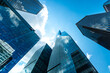 © byjeng - Low Angle View of Modern Glass Skyscrapers Under Blue Sky in Financial District