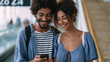 © Katerina Bond - Smiling young couple checks a smartphone together inside a bright modern transit terminal.