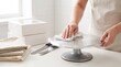 © Stitch - Hands using a white cloth to wipe clean a metal cake turntable on a table