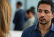 © Pixel-Shot - Serious man with a beard in a blue shirt looking away during a business meeting or discussion, His expression conveys thoughtfulness and concentration