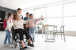 © Pixel-Shot - Mature teacher in wheelchair with little pupils taking selfie at school