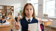 © VectorVille - Young girl making silly face while holding a tablet in classroom - Concept of back to school