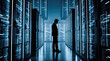 © Celt Studio - Thoughtful male business executive standing inside large dark modern futuristic data center room filled with tall glowing blue network server computer cabinets