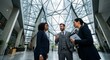 © Wendy - Diverse professional business team having a meeting in a modern glass office building lobby.