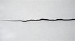 © PixelPulse - Visible Horizontal Crack Across a White Concrete Surface Indicating Structural Weakness or Potential Damage