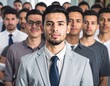 © Shodikin - Confident young businessman standing in front of diverse corporate team members in modern office environment
