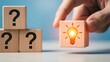 © MDRAFIQUL - Hand holding cube with light bulb icon solving problem and finding solution among question marks.
