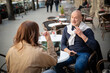 © sepy - Mature couple sitting at an round coffee table and having conversation at an outdoor cafe
