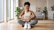 © Viktoriia - Smiling African American woman sitting on floor with white sneaker making heart shape with hand. Healthy lifestyle and fitness concept. Active girl at home during casual workout session.