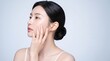 © Nerd Std.  - Side profile beauty portrait of a young woman touching smooth healthy skin against a gray background, clean skincare and moisturizing cosmetics concept with a fresh natural look