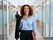 © UniqueStore - Professional woman with curly hair smiling while walking through a bright modern office corridor